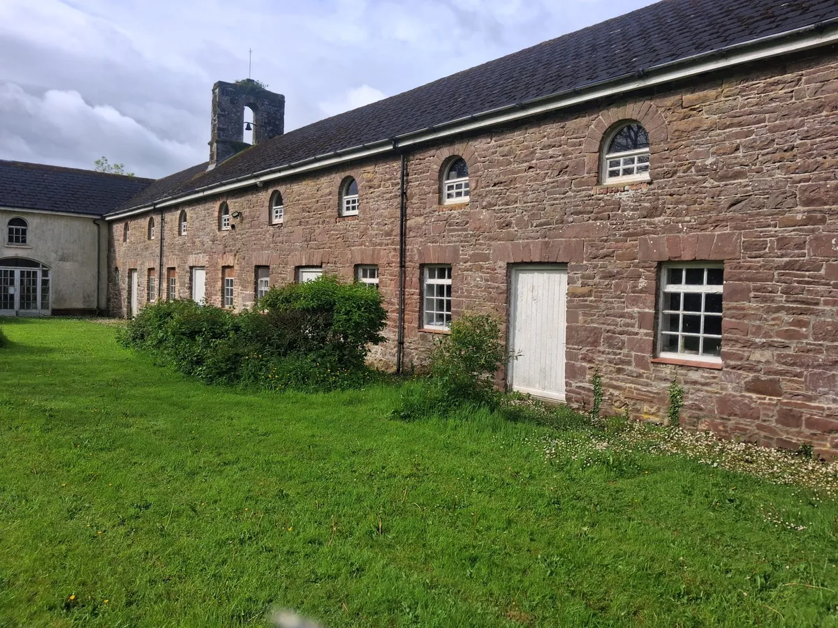 A long stone building with arched windows and a slate roof